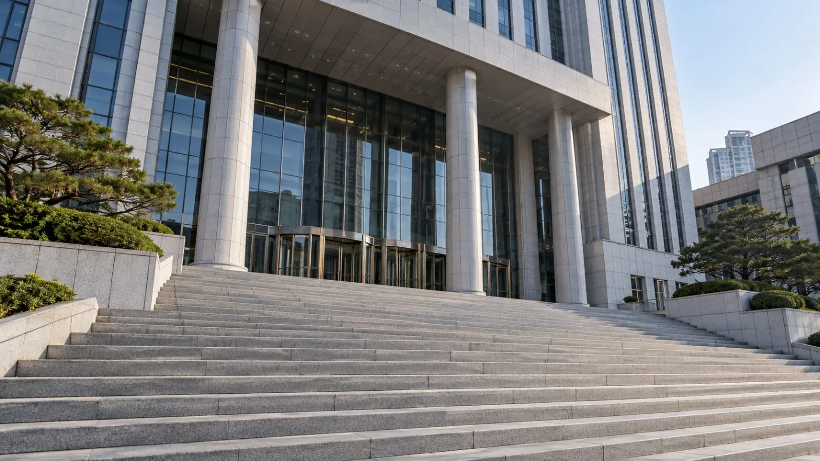 Empty courthouse steps lead toward a glass entrance in morning light / TokenPost.ai