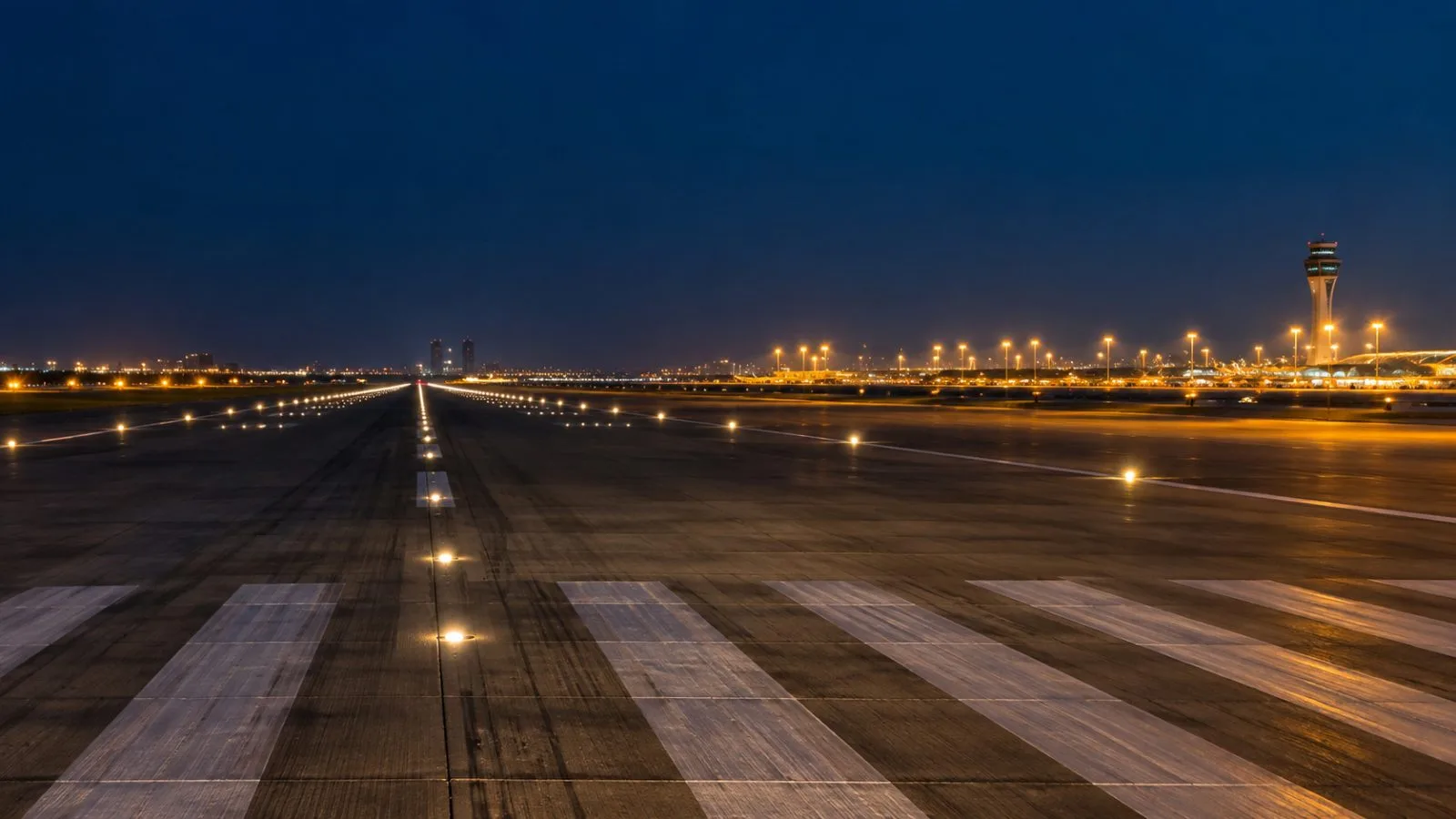 Runway lights trace an empty airfield beneath the night sky / TokenPost.ai
