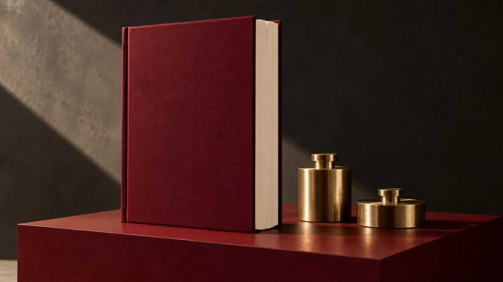 An unmarked earnings booklet stands beside two brass balance weights / TokenPost.ai